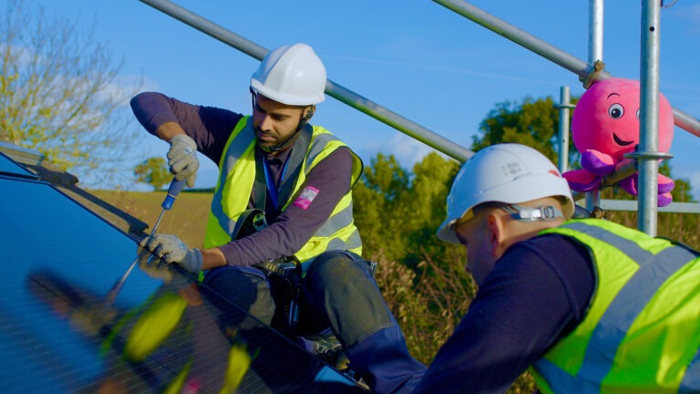 A photo of two Octopus engineers fitting solar panels onto a roof.